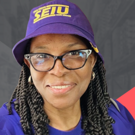 A close-up portrait of a smiling African American woman with twisted braids, cat-eye glasses, and a purple SEIU hat.