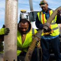 Photo credit: AFSCME, Two workers from the American Federation of State, County and Municipal Employees (AFSCME) performing a task with a large hose and a truck.