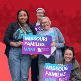 A small group of advocates from Missouri Jobs with Justice carry 'Missouri Families Win' posters in support of raising the minimum wage.